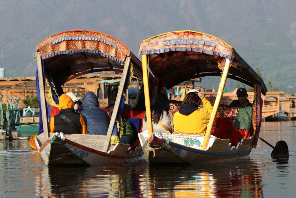  "Scenic view of Dal Lake with houseboats and snow-capped mountains in Srinagar, Kashmir."